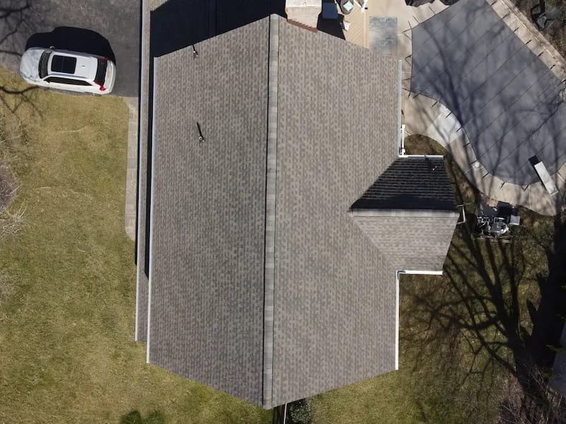 A detached shed with a green standing seam metal roof. 