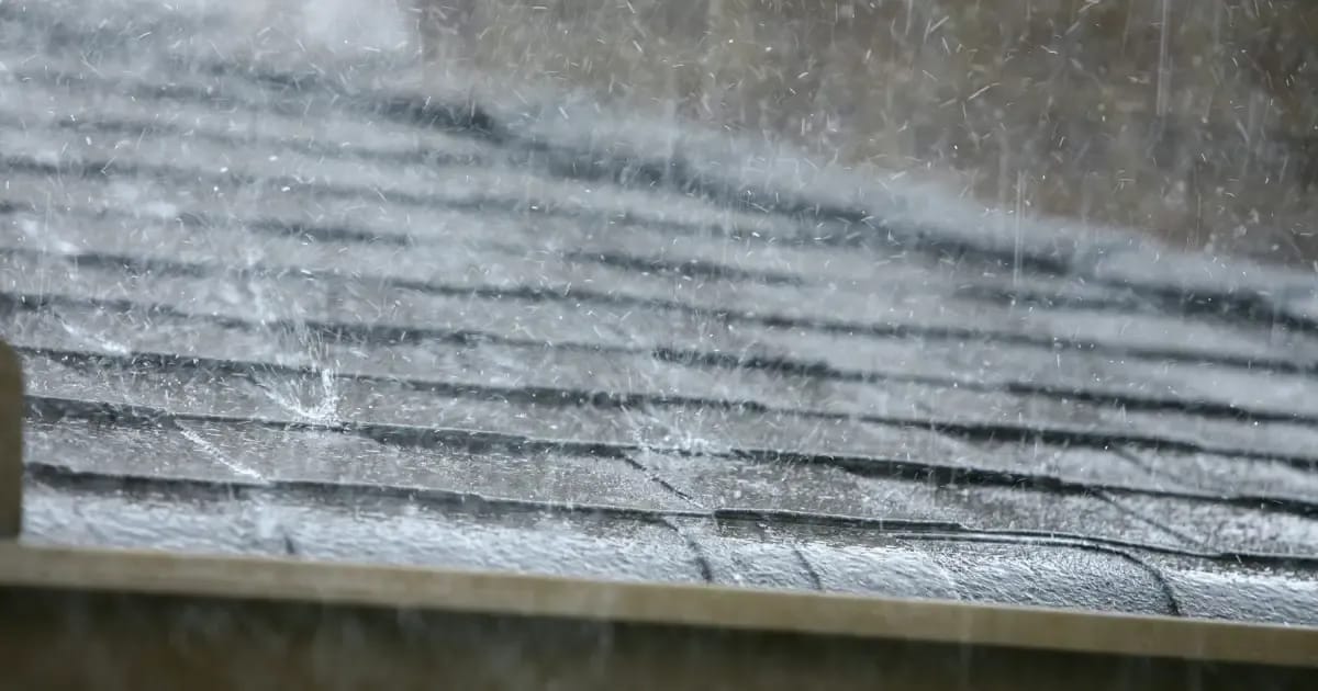 Heavy rain falling on a shingle roof