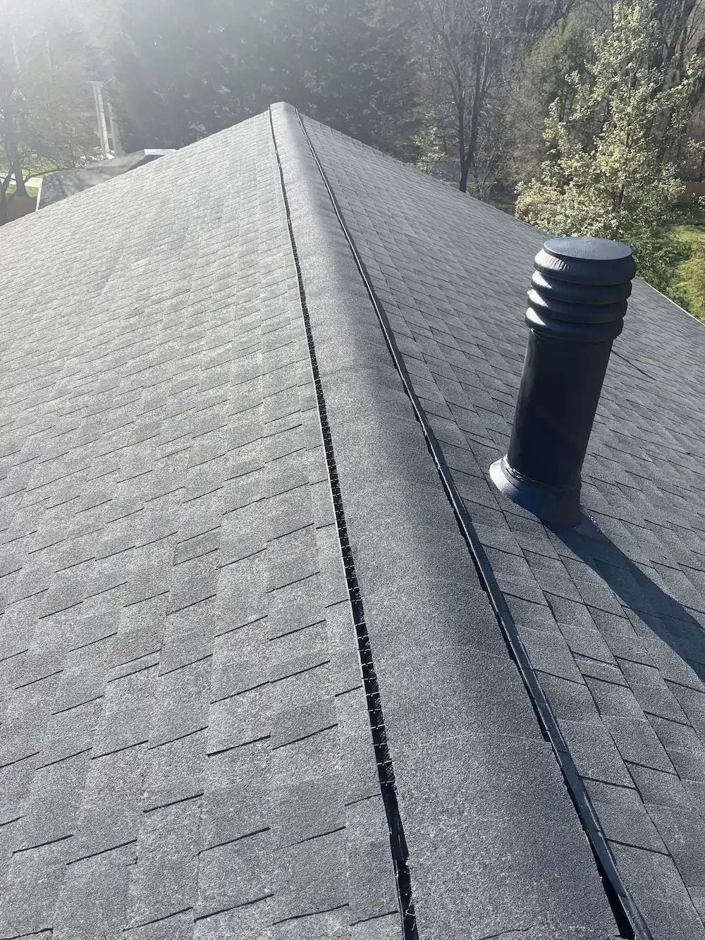 A detached shed with a green standing seam metal roof. 
