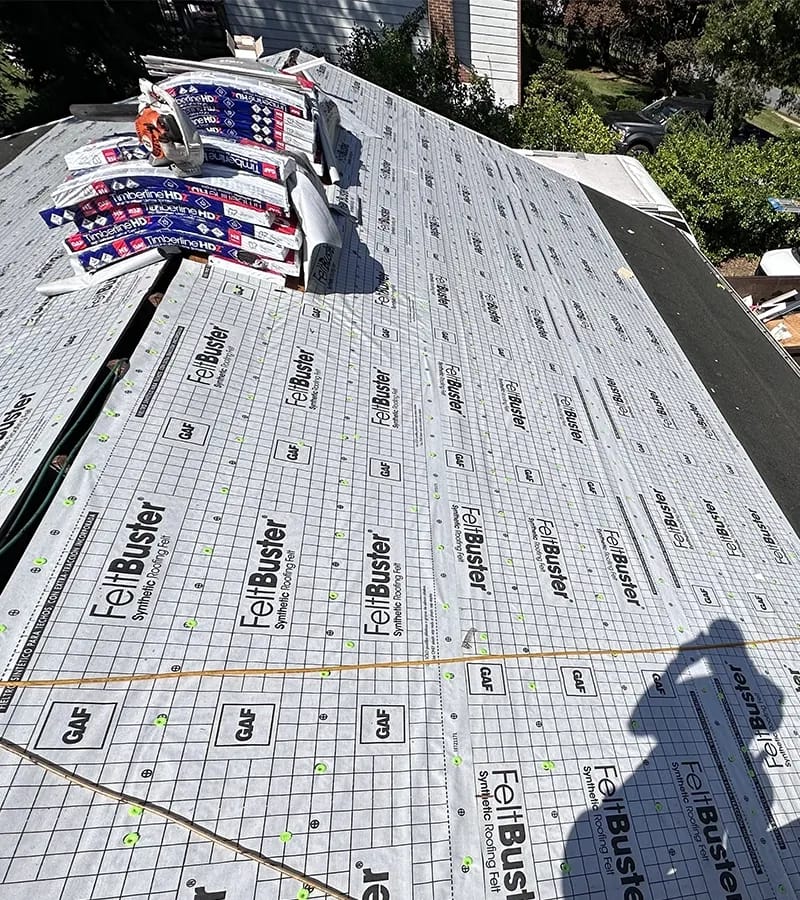 A detached shed with a green standing seam metal roof. 