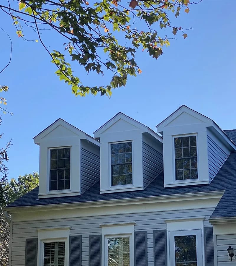A detached shed with a green standing seam metal roof. 