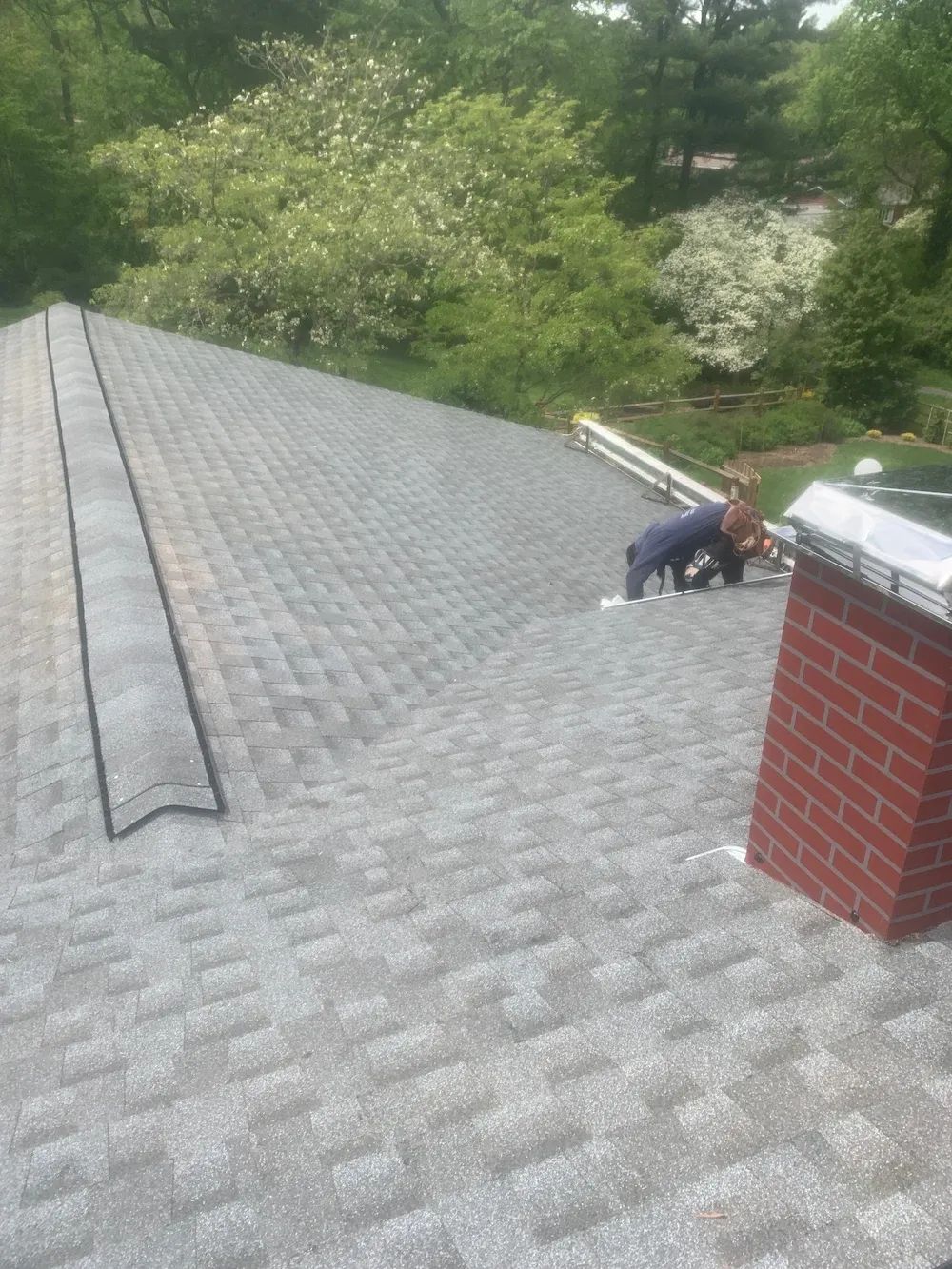 A detached shed with a green standing seam metal roof. 
