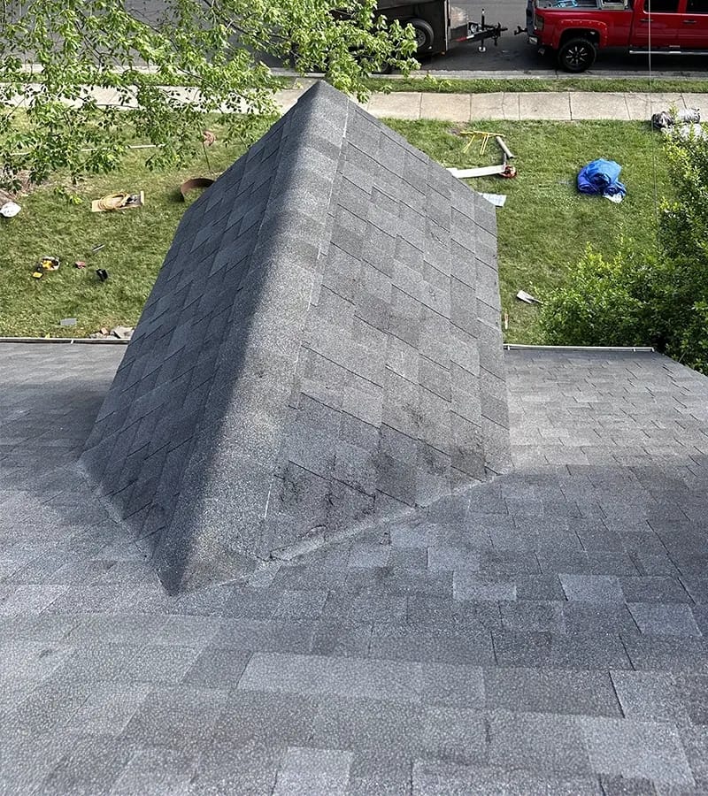 A detached shed with a green standing seam metal roof. 