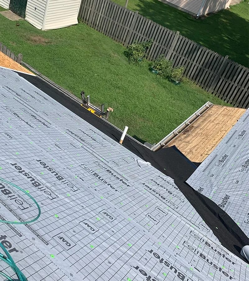 A detached shed with a green standing seam metal roof. 