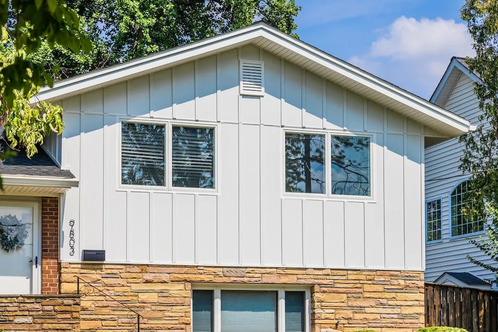 A detached shed with a green standing seam metal roof. 
