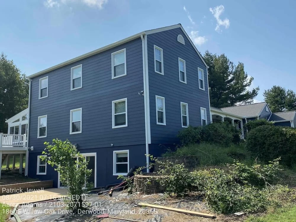 A detached shed with a green standing seam metal roof. 