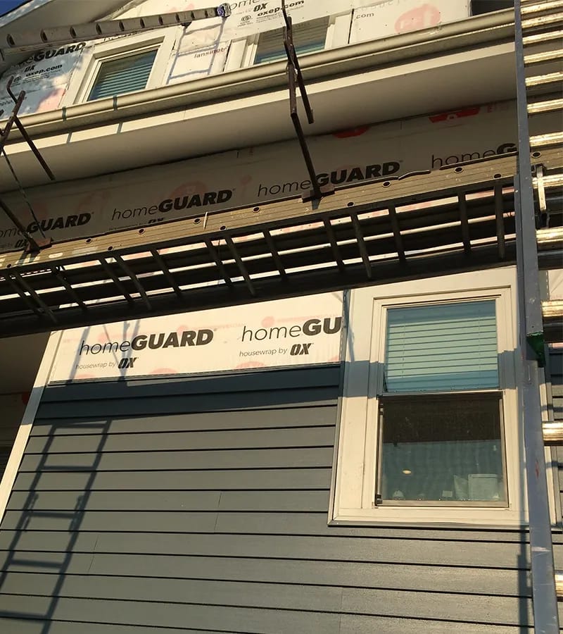 A detached shed with a green standing seam metal roof. 