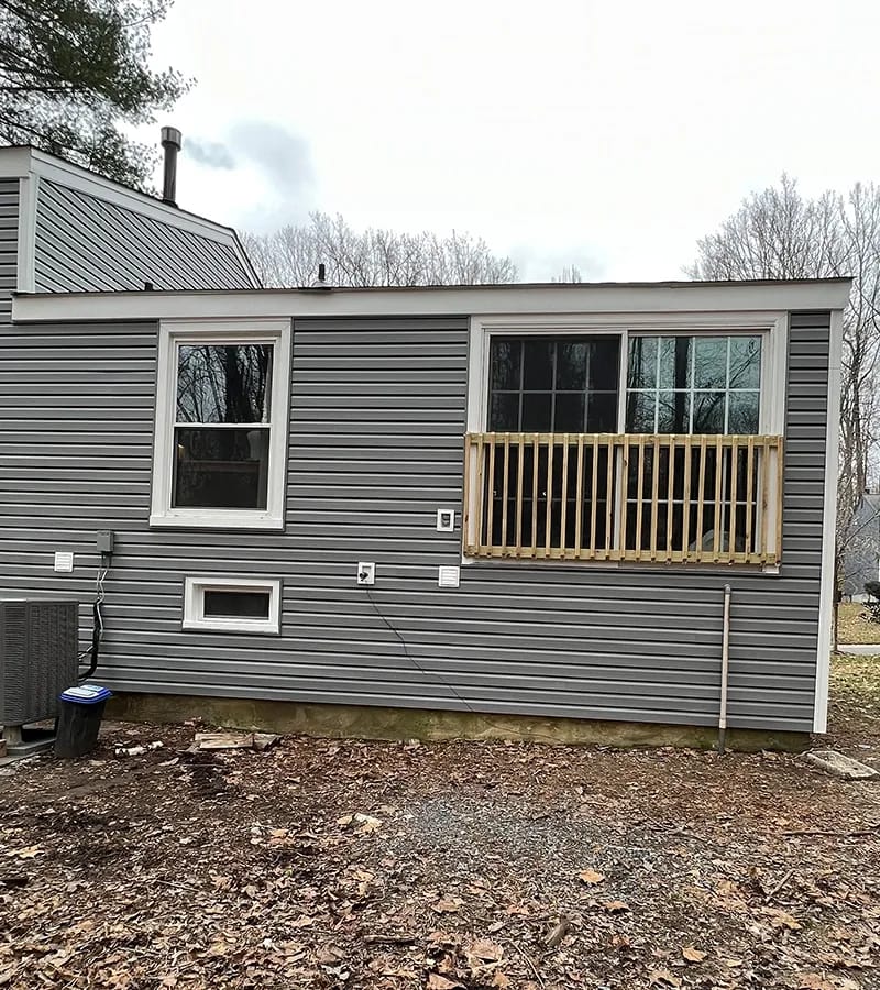 A detached shed with a green standing seam metal roof. 