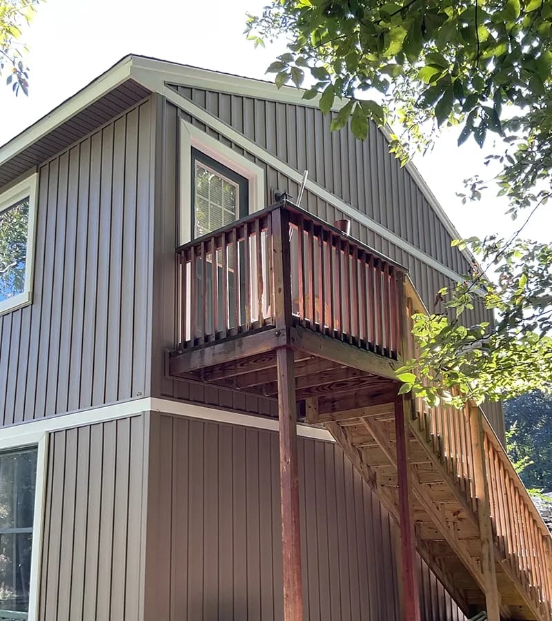 A detached shed with a green standing seam metal roof. 