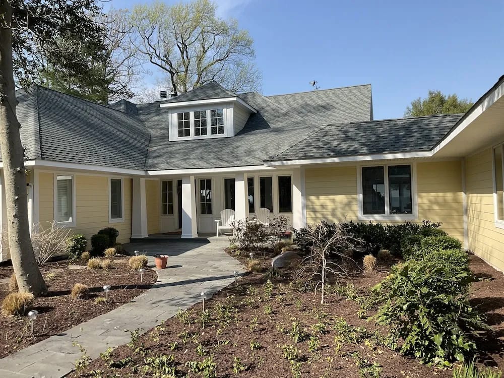 A detached shed with a green standing seam metal roof. 