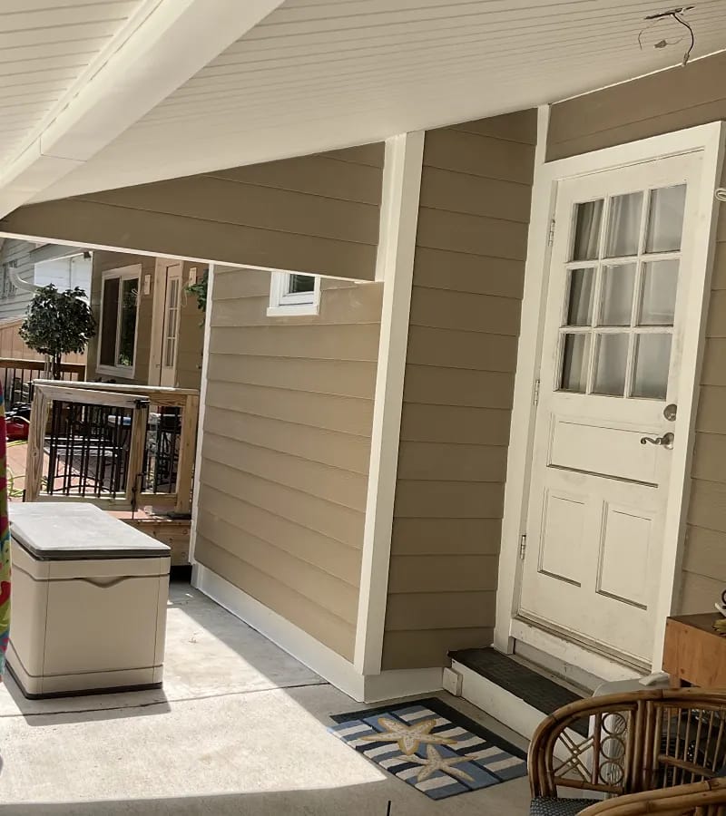 A detached shed with a green standing seam metal roof.