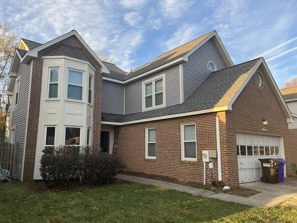 A detached shed with a green standing seam metal roof.