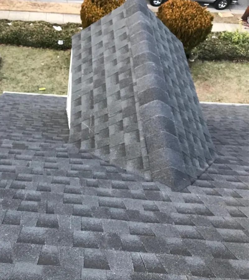 A detached shed with a green standing seam metal roof. 