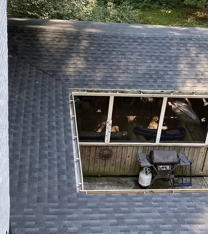 A detached shed with a green standing seam metal roof. 