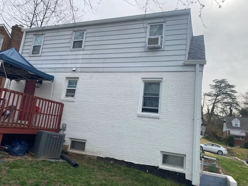 A detached shed with a green standing seam metal roof. 
