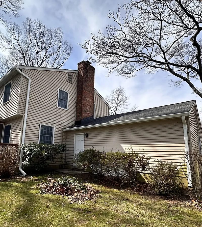 A detached shed with a green standing seam metal roof. 