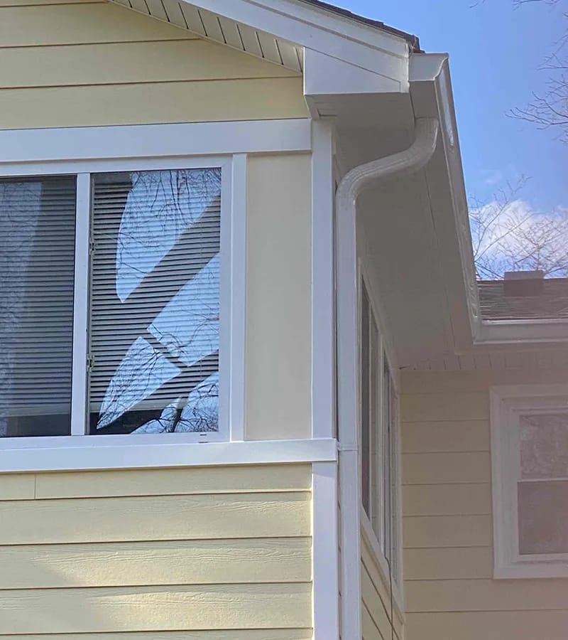 A detached shed with a green standing seam metal roof. 