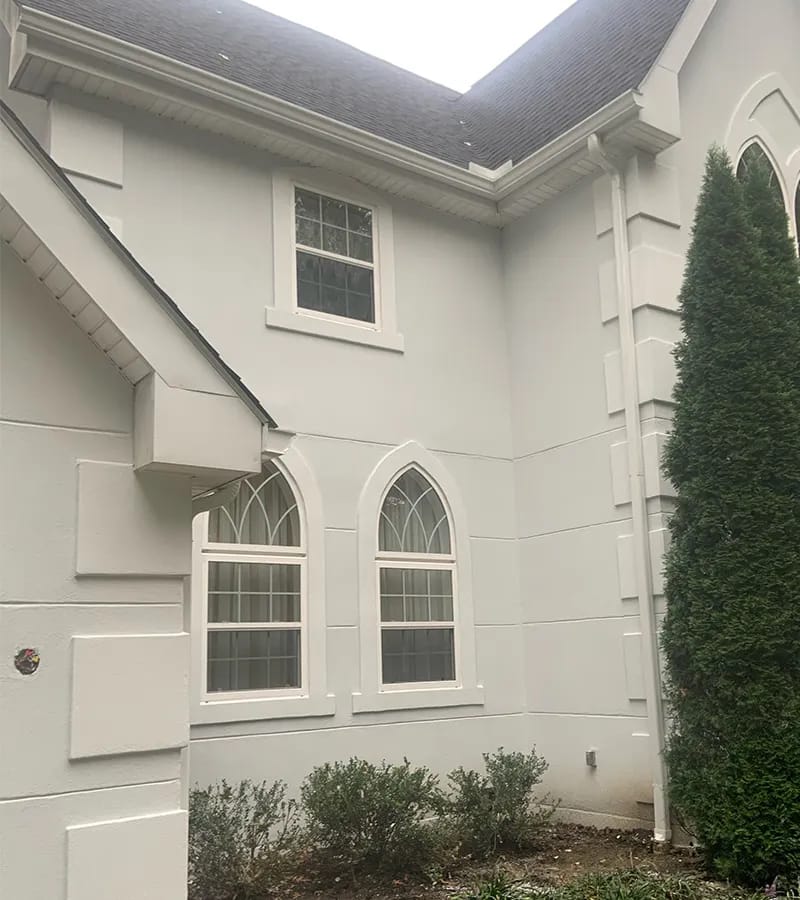 A detached shed with a green standing seam metal roof. 