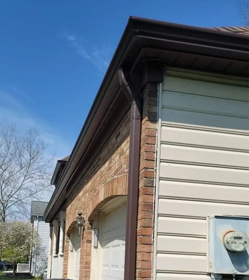 A detached shed with a green standing seam metal roof. 