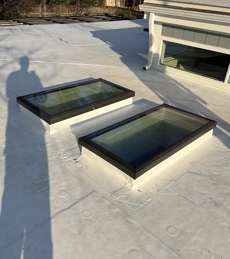A detached shed with a green standing seam metal roof. 