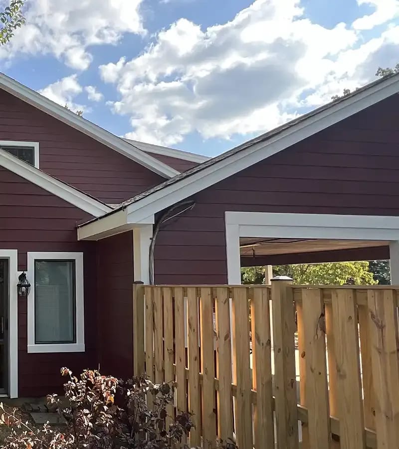 A detached shed with a green standing seam metal roof. 